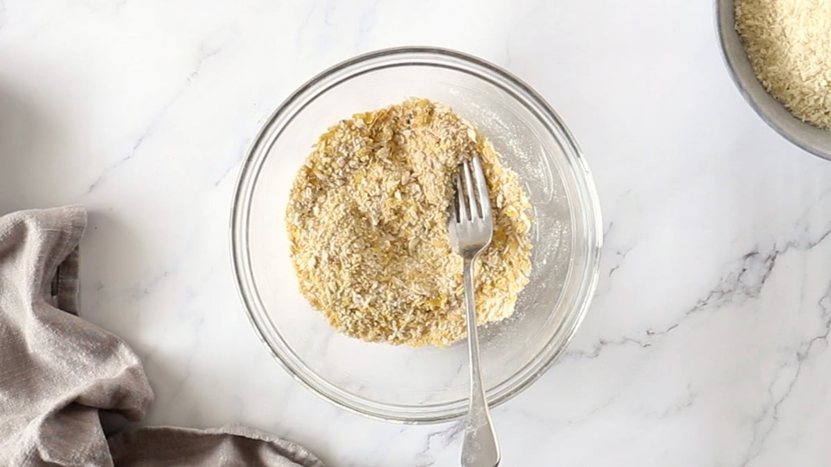 Panko breadcrumbs, nutritional yeast, and seasonings mixed together in a glass bowl