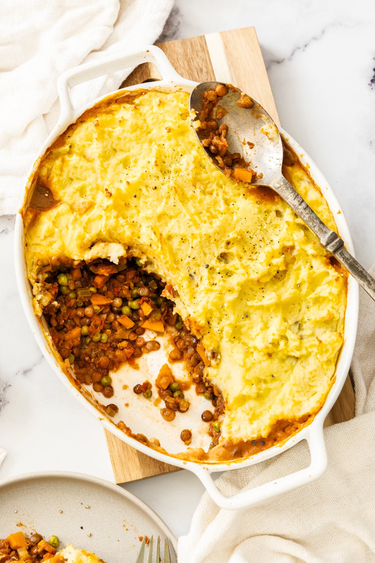 Overhead photo of vegetarian shepherd's pie with lentils, with a scoop removed.