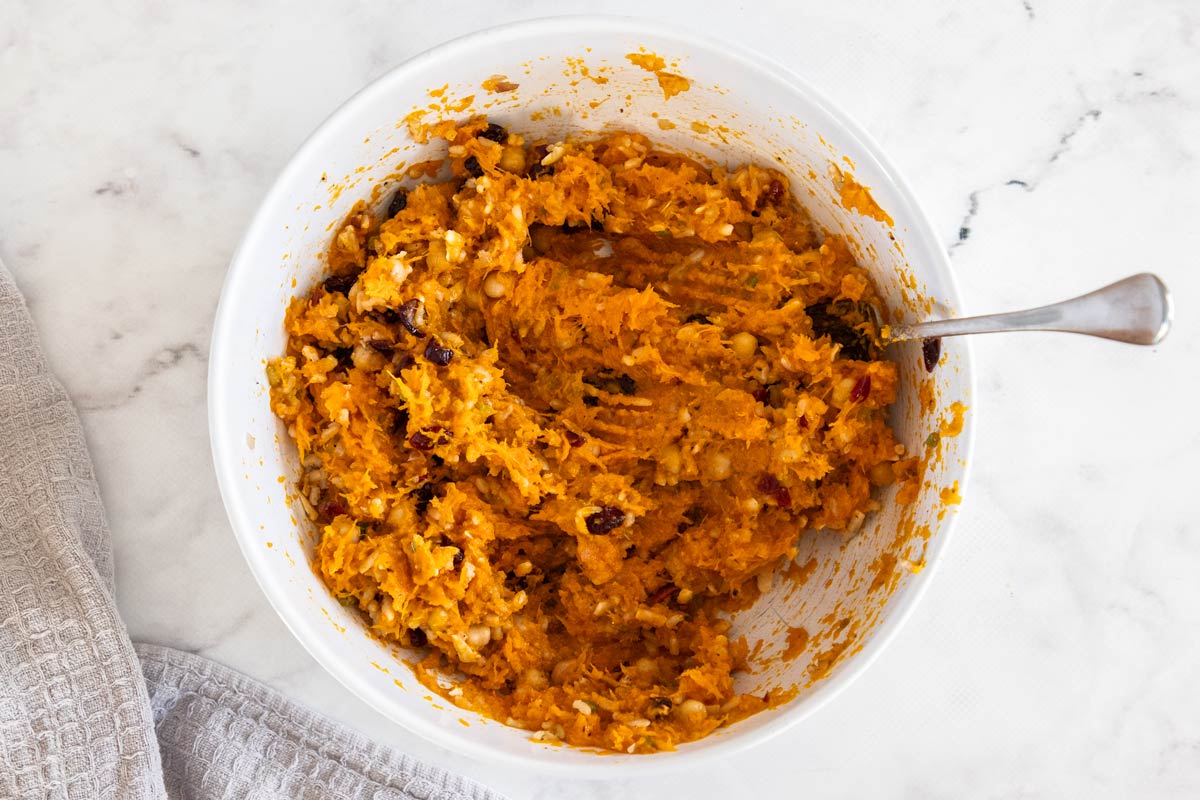 Overhead photo of brown rice stuffing with mashed butternut squash mixed in in a white bowl
