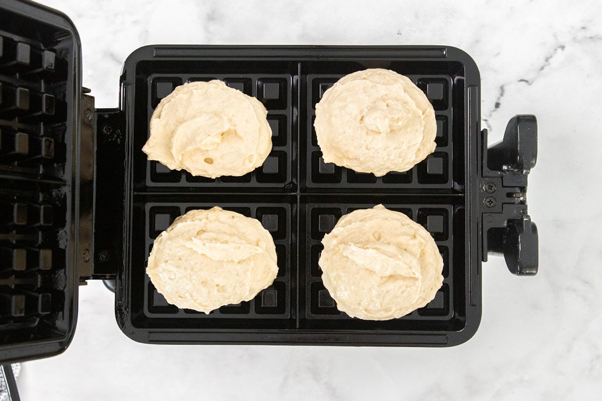 Overhead photo of cottage cheese waffles being cooked in a waffle iron.