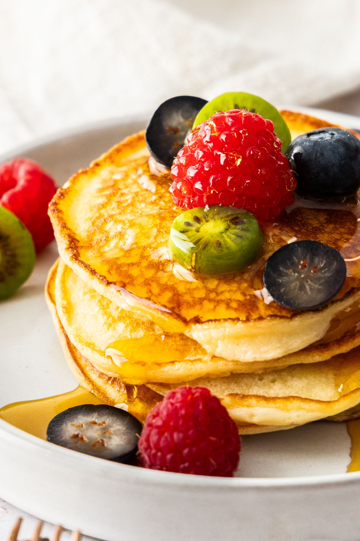 A stack of cottage cheese pancakes topped with fresh berries