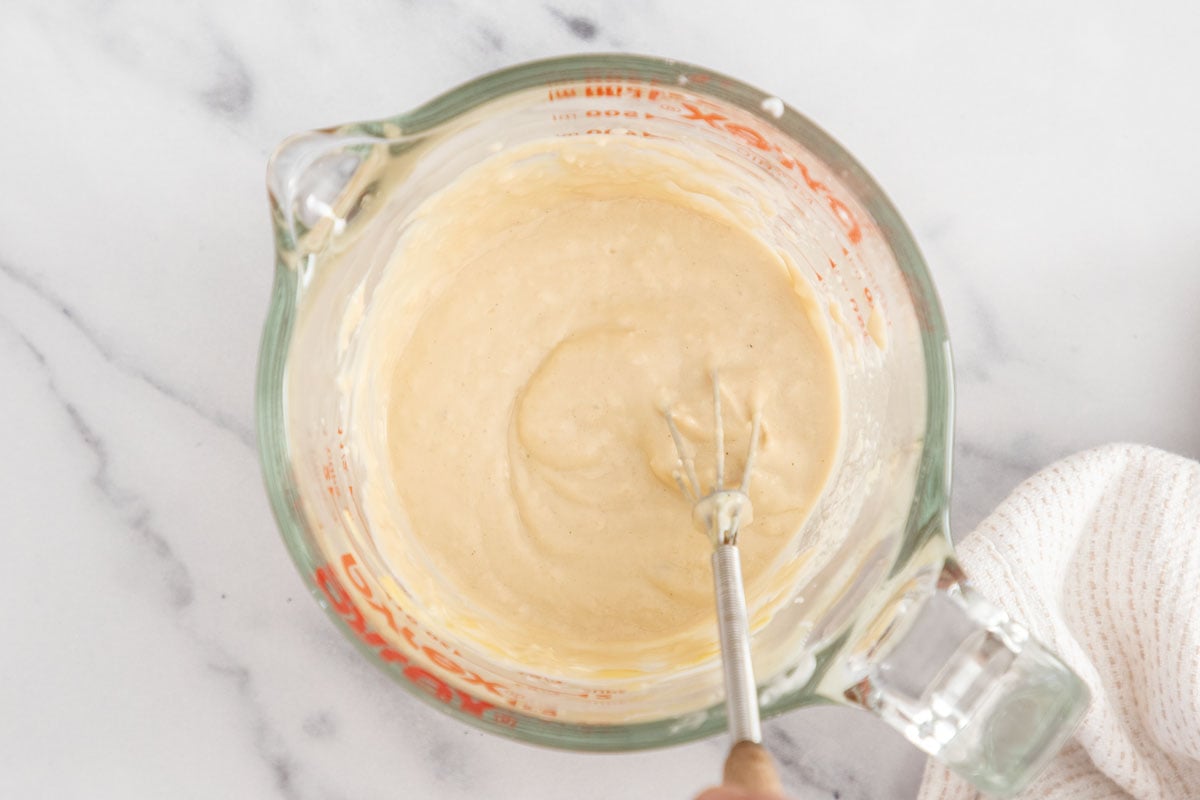 Vegetarain caesar salad dressing being whisked together in a pyrex measuring cup